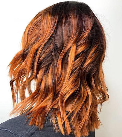Back of woman’s head with pumpkin spice balayage, created using Wella Professionals.