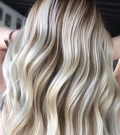 Back of woman’s head with wavy dirty blonde hair, created using Wella Professionals.