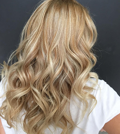 Back of woman’s head with long, satin golden blonde hair, created using Wella Professionals. 