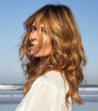 Photo of model with wavy blonde hair and Illuminage, created using Wella Professionals.