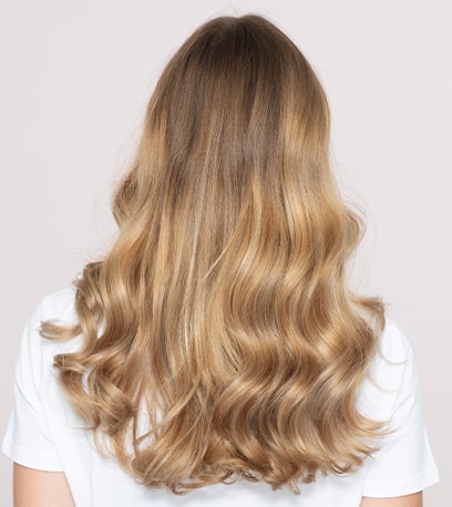 Photo of model with wavy blonde hair and Illuminage, created using Wella Professionals.