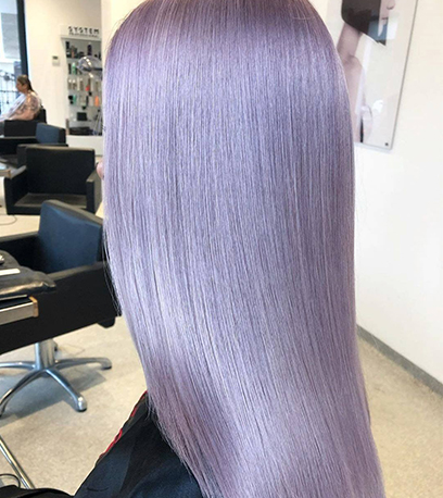 Aufnahme einer Frau von der Seite, mit langem, glatten, geschmeidigem Flieder-Look, kreiert mit Wella Professionals.