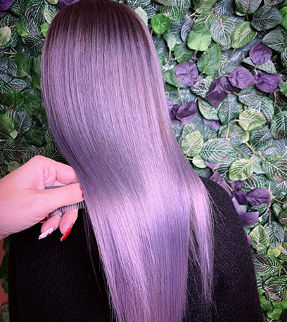 Back of woman’s head with long, straight, glossy violet hair, created using Wella Professionals.