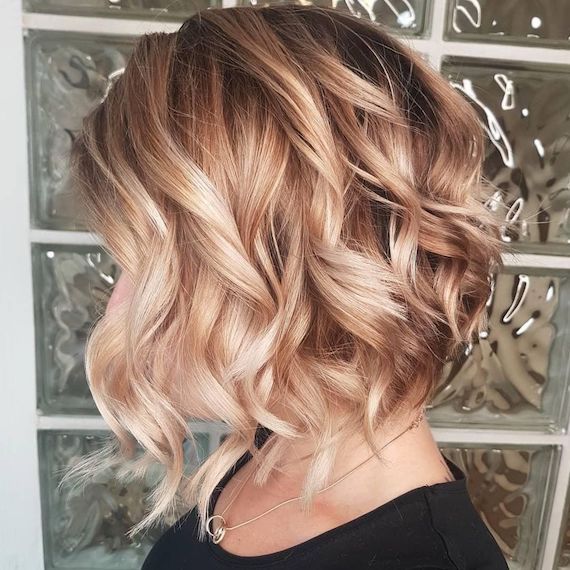 Seitenprofil einer Frau mit lockigem Haar und erdbeerblondem Balayage, kreiert mit Wella Professionals.